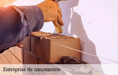 Maçon montant un mur en briques contre une façade